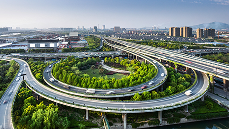 Intersecting highways with a backdrop of several tall buildings